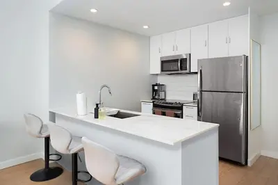 a kitchen with a white counter and a refrigerator at Exclusive 1BR Apt with NYC View in Hoboken