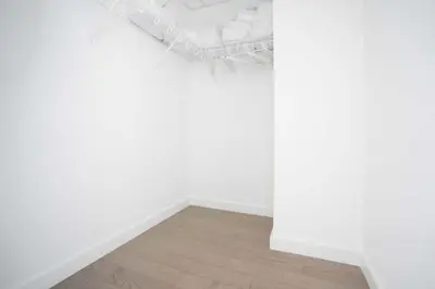 a white room with a bed and a wooden floor at Exclusive 1BR Apt with NYC View in Hoboken