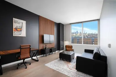a living room with a couch and a desk at Exclusive 1BR Apt with NYC View in Hoboken