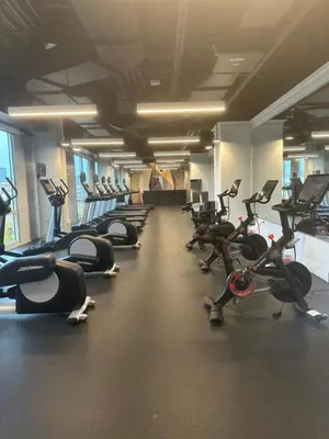 a gym with rows of exercise bikes and treadmills at Exclusive 1BR Apt with NYC View in Hoboken