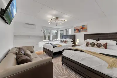 a large bedroom with two beds and a couch at Fire and Fun Luxe Stay w Pool Hot Tub and Game Room in Linden