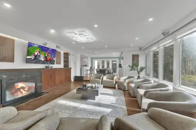 a living room with a couch and a fireplace at Fire and Fun Luxe Stay w Pool Hot Tub and Game Room in Linden