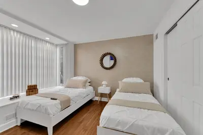 a bedroom with two beds and a mirror at Fire and Fun Luxe Stay w Pool Hot Tub and Game Room in Linden