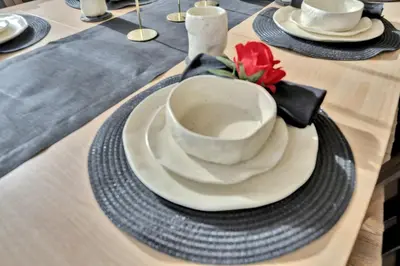 a table with a bowl and plates on a table at Fire and Fun Luxe Stay w Pool Hot Tub and Game Room in Linden