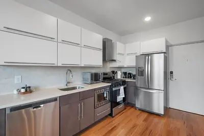 a kitchen with white cabinets and stainless steel appliances at Courtyard Studio - Serene Space Gym Wi-Fi in Philadelphia
