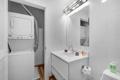 a white bathroom with a sink and a mirror at Courtyard Studio - Serene Space Gym Wi-Fi in Philadelphia