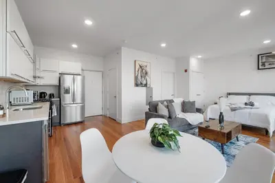 a kitchen and living room with a couch and a table at Courtyard Studio - Serene Space Gym Wi-Fi in Philadelphia