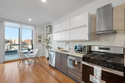 a kitchen with stainless steel appliances and a large window at Courtyard Studio - Serene Space Gym Wi-Fi in Philadelphia
