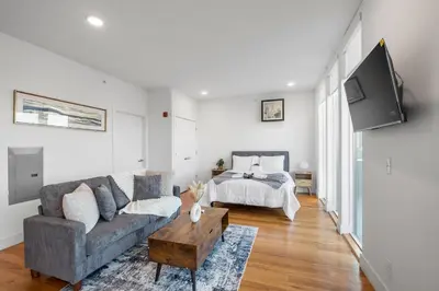 a living room with a couch and a bed at Designer Studio Loft - Balcony Pool Gym in Philadelphia