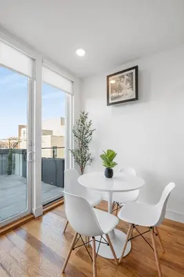 a white dining room with a white table and chairs at Designer Studio Loft - Balcony Pool Gym in Philadelphia