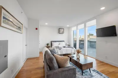 a living room with a bed and a couch at Designer Studio Loft - Balcony Pool Gym in Philadelphia
