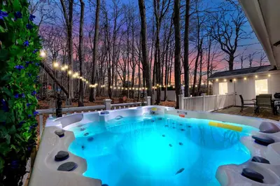 a hot tub on a patio at night at Palomino Ranch namaste-sunroom, hot tub, game room, king beds, fire pit, BBQ, pet-friendly in Tobyhanna