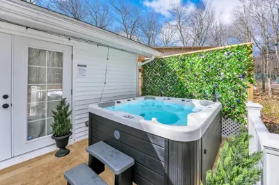 a hot tub in the backyard of a house at Palomino Ranch namaste-sunroom, hot tub, game room, king beds, fire pit, BBQ, pet-friendly in Tobyhanna