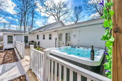 a hot tub on the deck of a house at Palomino Ranch namaste-sunroom, hot tub, game room, king beds, fire pit, BBQ, pet-friendly in Tobyhanna
