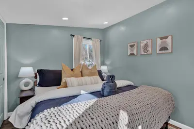 a bedroom with a large bed with blue walls at Palomino Ranch namaste-sunroom, hot tub, game room, king beds, fire pit, BBQ, pet-friendly in Tobyhanna