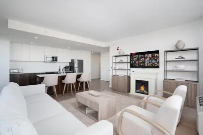 a living room with white furniture and a fireplace at Ultra Luxury Apt - Panoramic NYC View - Minutes to City in Hoboken