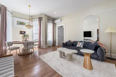 a living room with a blue couch and a table at Bright & Modern - 35 Mins to NYC - Extended Stays in Jersey City