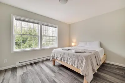 a bedroom with a bed and two windows at Spacious 5BR Home In Heart Of Poconos By Camelback Skiing Swimming Lake in Tobyhanna