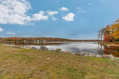 a view of a lake with a boat on the water at Spacious 5BR Home In Heart Of Poconos By Camelback Skiing Swimming Lake in Tobyhanna