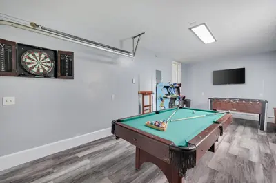 a room with a pool table and a clock at Spacious 5BR Home In Heart Of Poconos By Camelback Skiing Swimming Lake in Tobyhanna