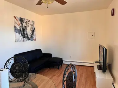 a living room with a couch and a tv at Amazing three bedrooms Apartment near EWR and NYC in Linden