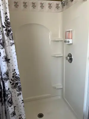 a white shower with a black and white shower curtain at Amazing three bedrooms Apartment near EWR and NYC in Linden