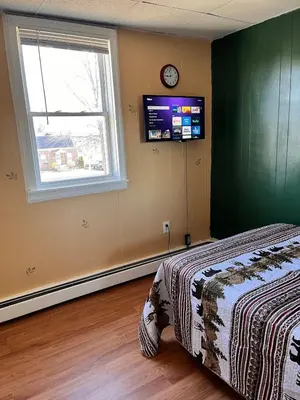 a bedroom with a bed and a window and a television at Amazing three bedrooms Apartment near EWR and NYC in Linden