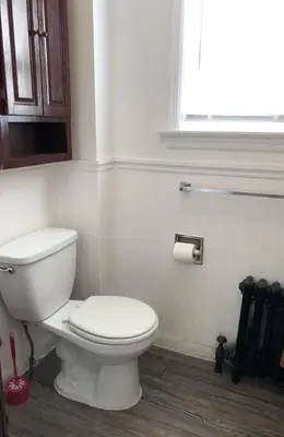 a bathroom with a white toilet and a window at Private house with 3 bedrooms and 1 bathroom, free parking, convenient to NYC Manhattan bus and train, MetLife Stadium FIFA World Cup 35 minutes away in Perth Amboy