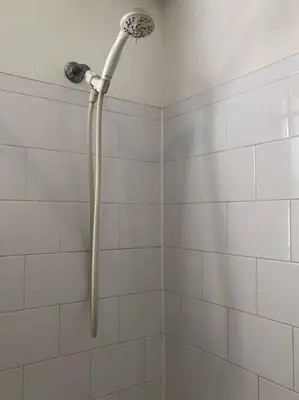 a shower with a shower head in a bathroom at Private house with 3 bedrooms and 1 bathroom, free parking, convenient to NYC Manhattan bus and train, MetLife Stadium FIFA World Cup 35 minutes away in Perth Amboy