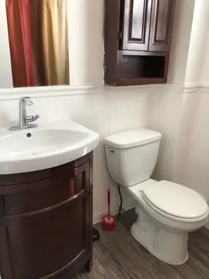 a bathroom with a toilet and a sink at Private house with 3 bedrooms and 1 bathroom, free parking, convenient to NYC Manhattan bus and train, MetLife Stadium FIFA World Cup 35 minutes away in Perth Amboy
