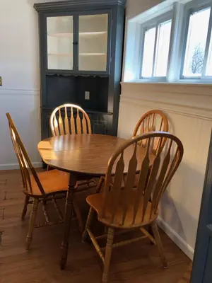 a wooden table with three chairs and a wooden table and two windows at Private house with 3 bedrooms and 1 bathroom, free parking, convenient to NYC Manhattan bus and train, MetLife Stadium FIFA World Cup 35 minutes away in Perth Amboy