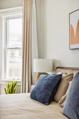 a bedroom with a bed with pillows and a window at Chic & Modern - 30 Mins to NYC in Jersey City
