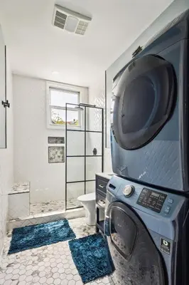a bathroom with a washing machine and a toilet at Chic & Modern - 30 Mins to NYC in Jersey City