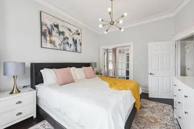 a bedroom with a large bed and a chandelier at Chic & Modern - 35 Mins to NYC - Extended Stays in Jersey City