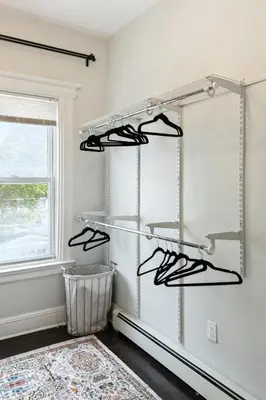 a room with three shelves with shoes in it at Chic & Modern - 35 Mins to NYC - Extended Stays in Jersey City