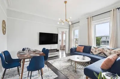 a living room with a blue couch and a table at Chic & Modern - 35 Mins to NYC - Extended Stays in Jersey City