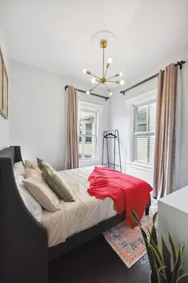 a bedroom with a bed with a red blanket on it at Chic & Modern - 35 Mins to NYC - Extended Stays in Jersey City