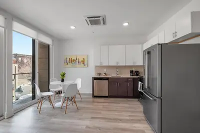 a kitchen with a table and chairs and a refrigerator at Cozy Luxe Studio - Workstation WasherDryer in Philadelphia