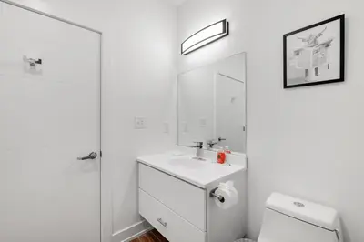 a white bathroom with a sink and a toilet at Cozy Luxe Studio - Workstation WasherDryer in Philadelphia