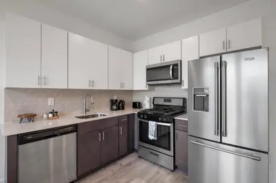 a kitchen with white cabinets and stainless steel appliances at Cozy Luxe Studio - Workstation WasherDryer in Philadelphia