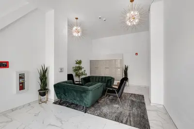 a living room with a green couch and a chair at Urban Retreat Studio - Balcony Smart Design in Philadelphia