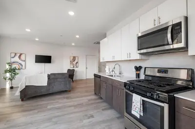 a kitchen with a stove top oven next to a couch at Urban Retreat Studio - Balcony Smart Design in Philadelphia