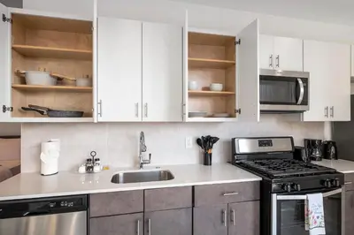 a kitchen with white cabinets and a sink at Urban Retreat Studio - Balcony Smart Design in Philadelphia