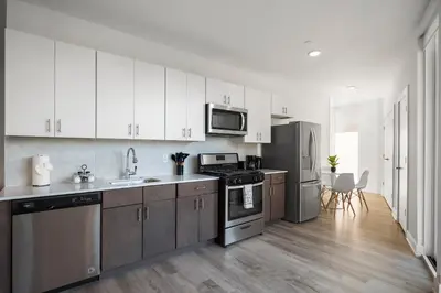 a kitchen with white cabinets and stainless steel appliances at Urban Retreat Studio - Balcony Smart Design in Philadelphia