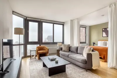 a living room with a couch and a bed at Tribeca Studio w City views Gym Pool NYC-110 in New York