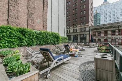 a deck with chairs and plants on a building at Tribeca Studio w City views Gym Pool NYC-110 in New York