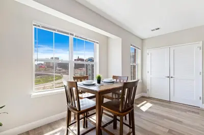 a dining room with a table and chairs and a large window at Downtown NWK 1BR- Free Parking Easy NYC Access in Newark