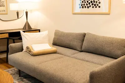 a couch with a book on it in a living room at Sosuite at The Jefferson - Fishtown in Philadelphia