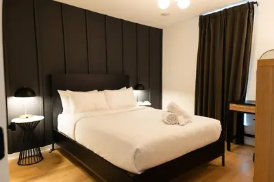 a bedroom with a large bed with a black headboard at Sosuite at The Jefferson - Fishtown in Philadelphia