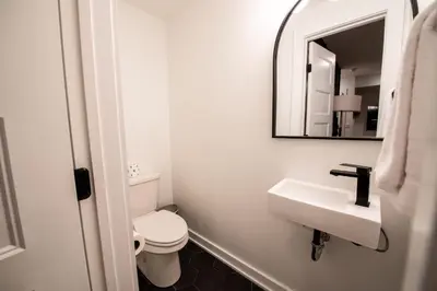 a bathroom with a toilet and a sink and a mirror at Sosuite at The Jefferson - Fishtown in Philadelphia